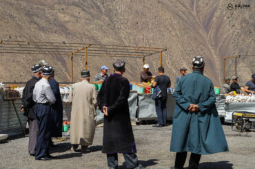 Tajik men in traditional clothes in market in the mountains