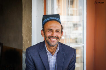 Tajik man smiling in traditional skullcap